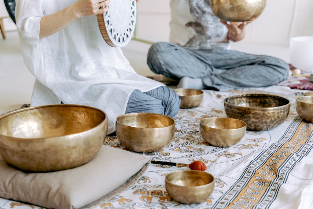 singing bowls placed beside two individuals 