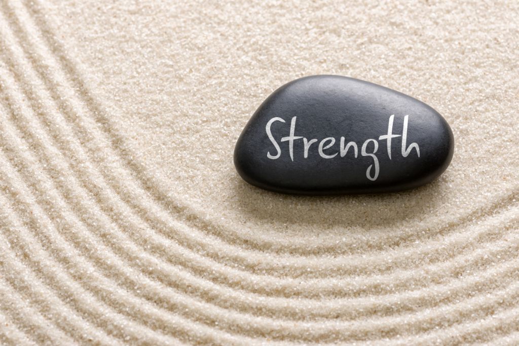 a stone with the word "strength" written on it.