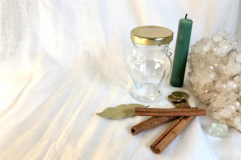 jar and candles with crystals and coins on a table depicting money and success spell