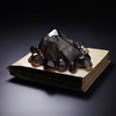 Cairngorm Smoky Quartz together with black stones situated on top of a white book