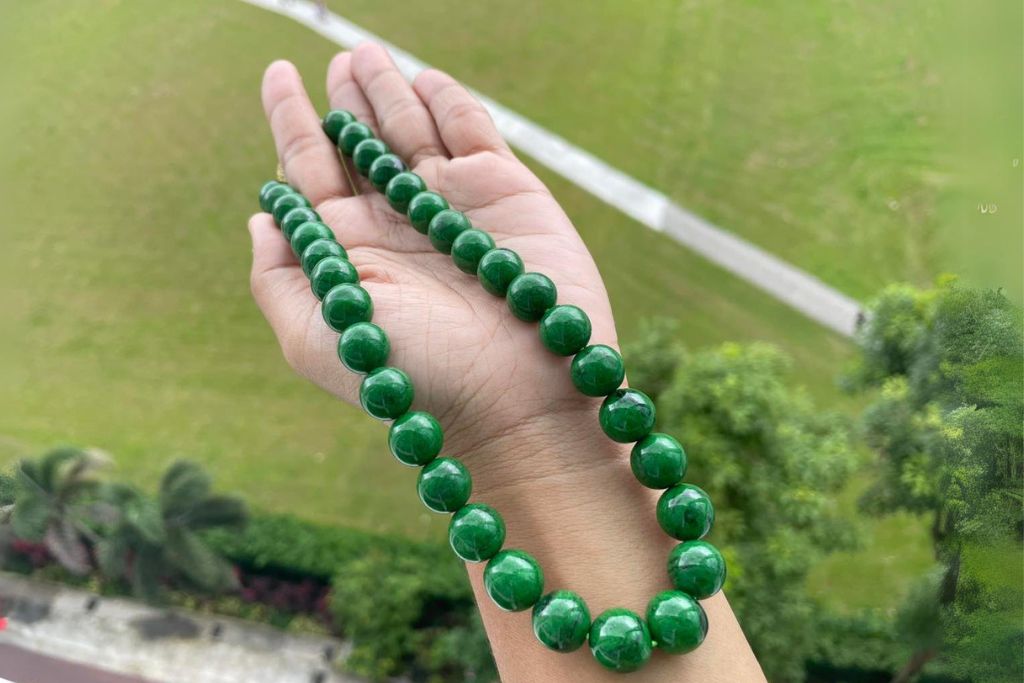 a hand holding Chloromelanite beads