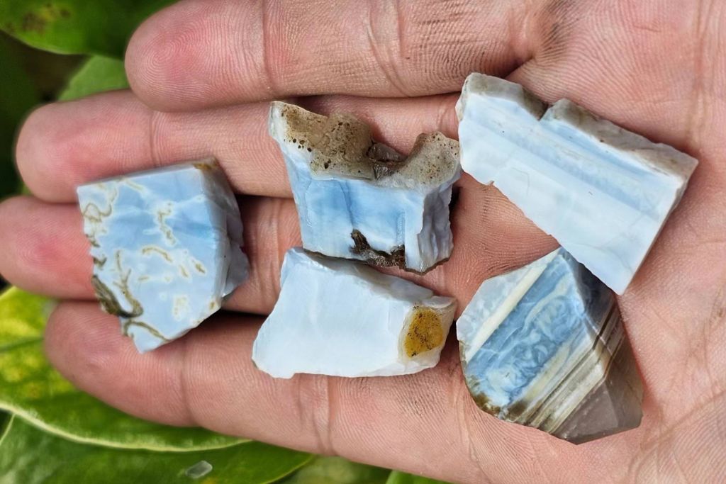 owyhee blue opal crystals on the palm of a person