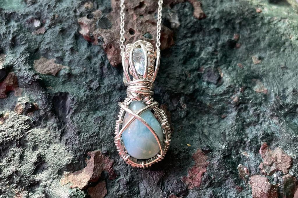 blue moon quartz necklace on a rock surface