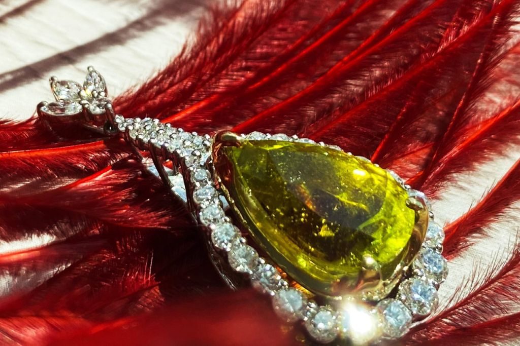 canary tourmaline jewelry placed on top of a red feather