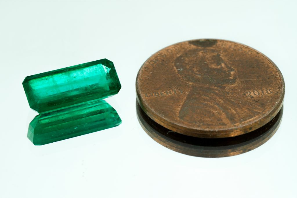 colombian emerald beside a coin