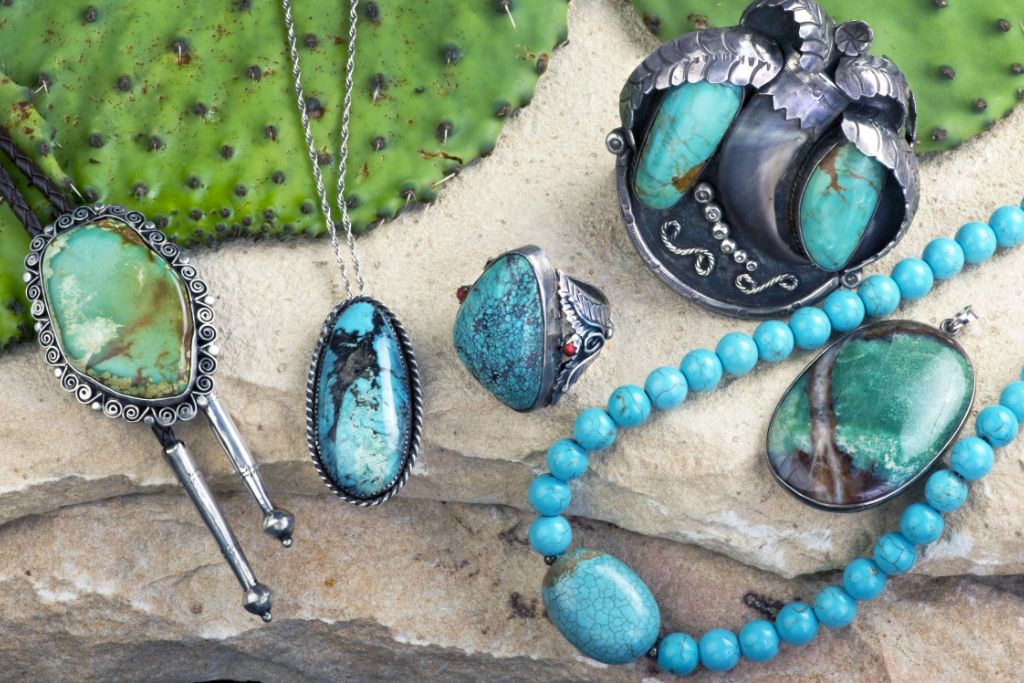 old navajo turquoise jewelries situated on white slab together with desert cactus