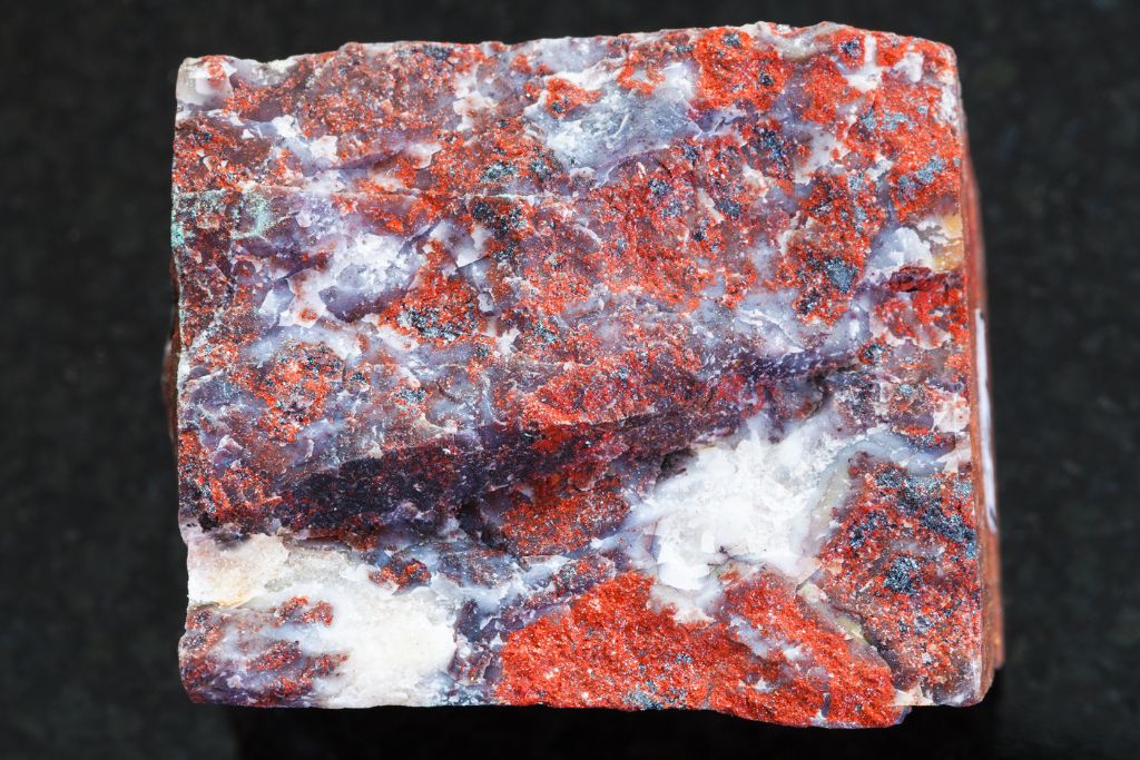 rough poppy jasper situated on granite platform