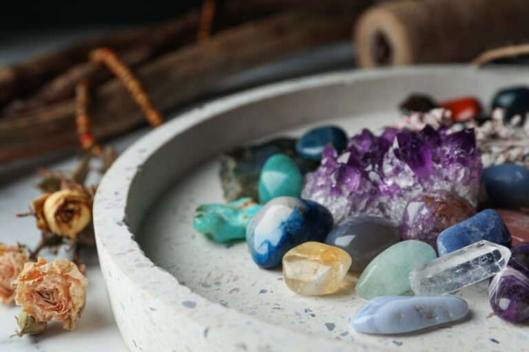 Pile of different tiny gemstones in a circular tray.