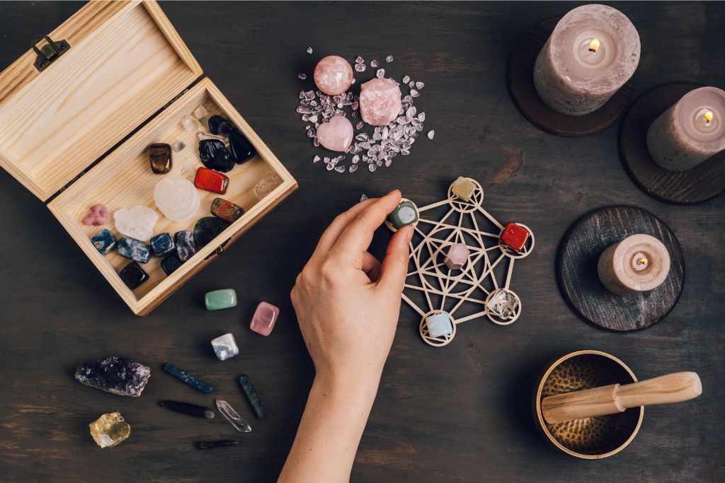 a hand arranging a crystal on an altar