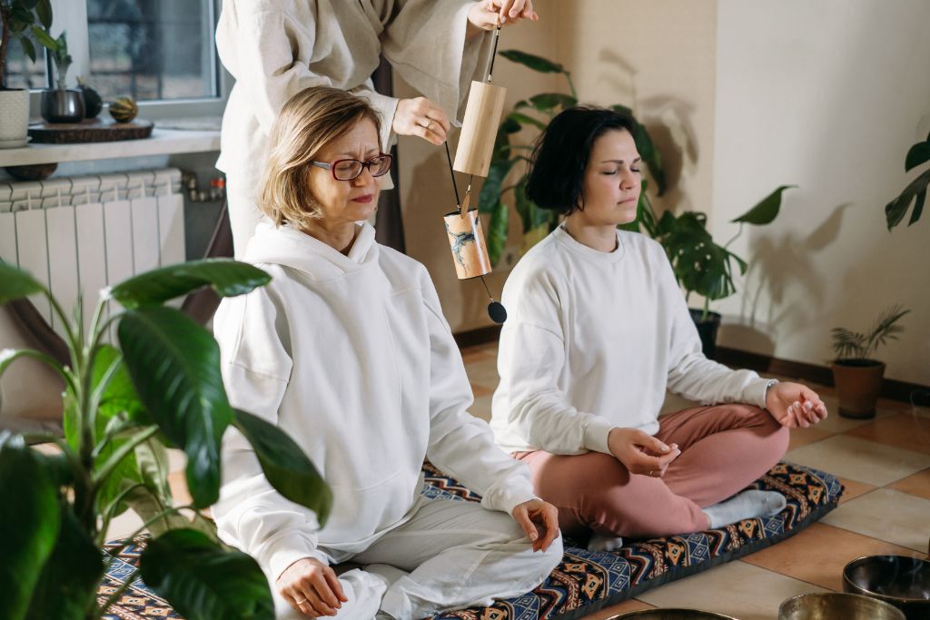 People meditating with bells