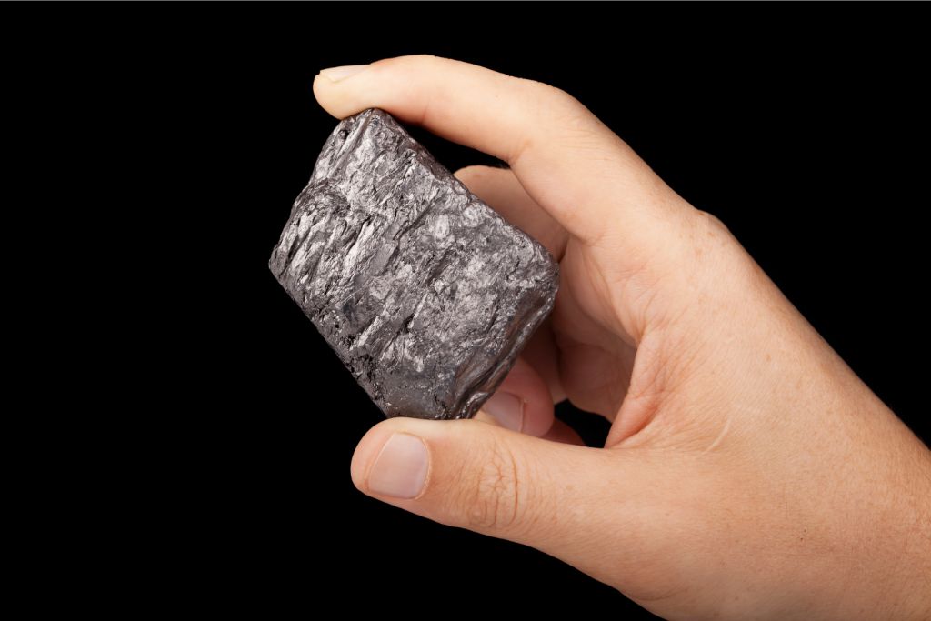 graphite chunk scrutinized by hand