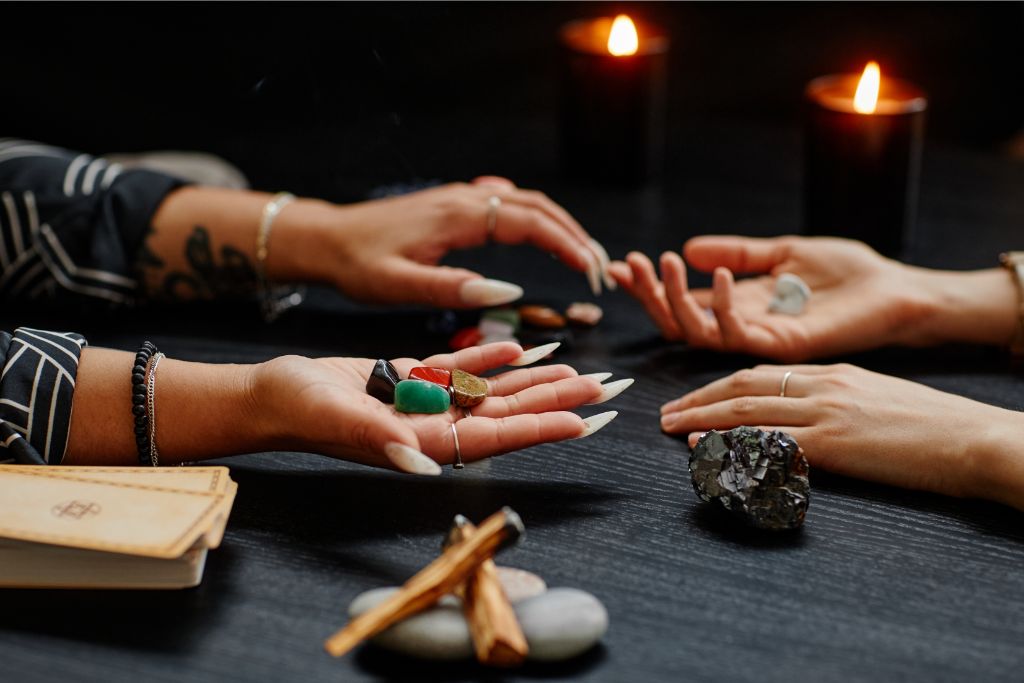 2 person doing fortune telling rituals using crystals 