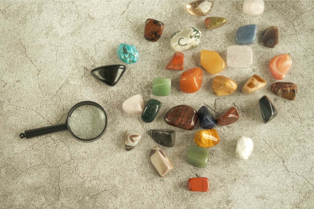 assorted crystals and magnifying lens on a stone background