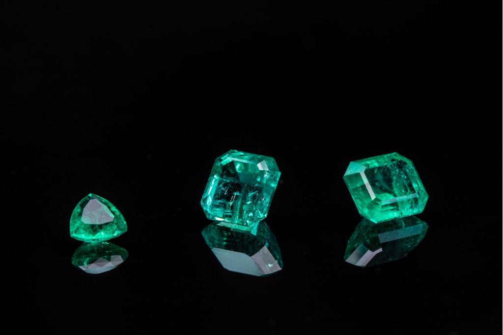 zambian emeralds with different shapes on back background